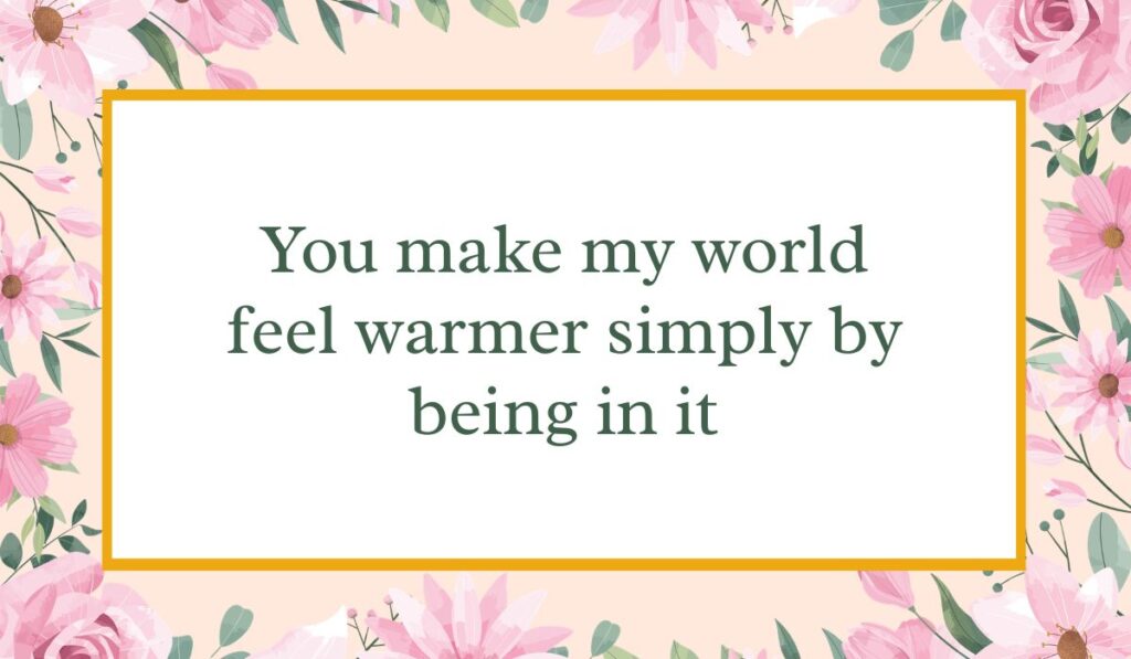 Bright white card enclosed by an elegant border of pink watercolor roses and green leaves with a thin gold inner frame, displaying tender best morning messages for him: "You make my world feel warmer simply by being in it".