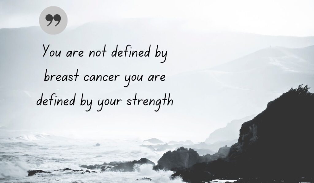 Atmospheric black and white coastal photograph of crashing ocean waves against rugged cliffs, centered with a dark gray quotation icon framing supportive encouraging quotes for breast cancer: "You are not defined by breast cancer you are defined by your strength".