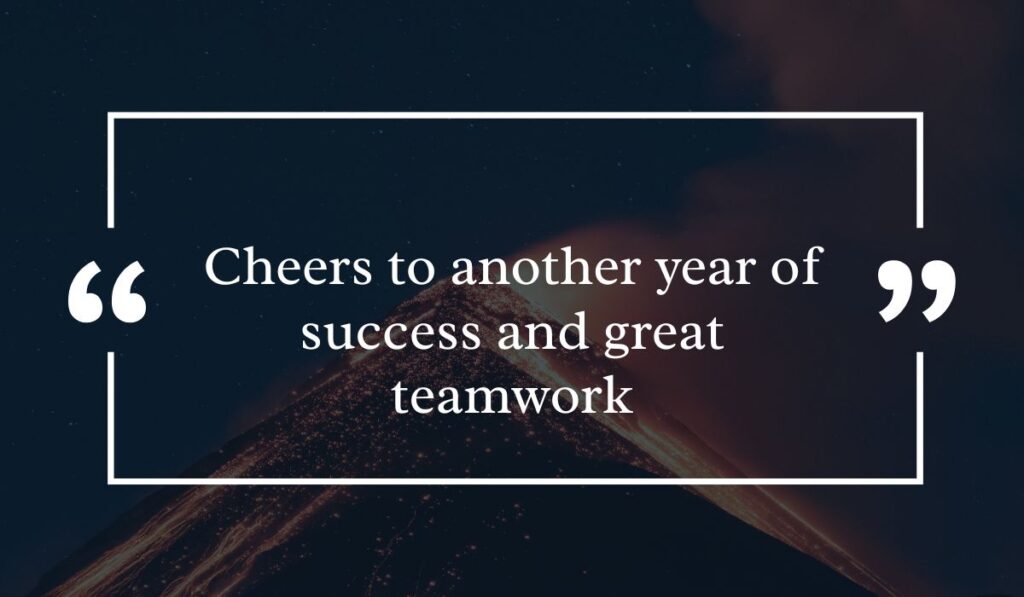 Dramatic dark night sky background featuring a lit volcanic peak at night, centered with a white quotation box highlighting inspiring happy birthday wishes for coworker: "Cheers to another year of success and great teamwork".