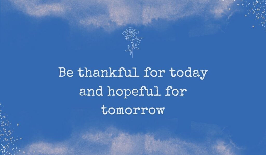 Rich royal blue watercolor background with subtle stardust detailing in the corners and a fine white line-art rose centered at the top, framing hopeful inspirational quotes for the month of november: "Be thankful for today and hopeful for tomorrow".