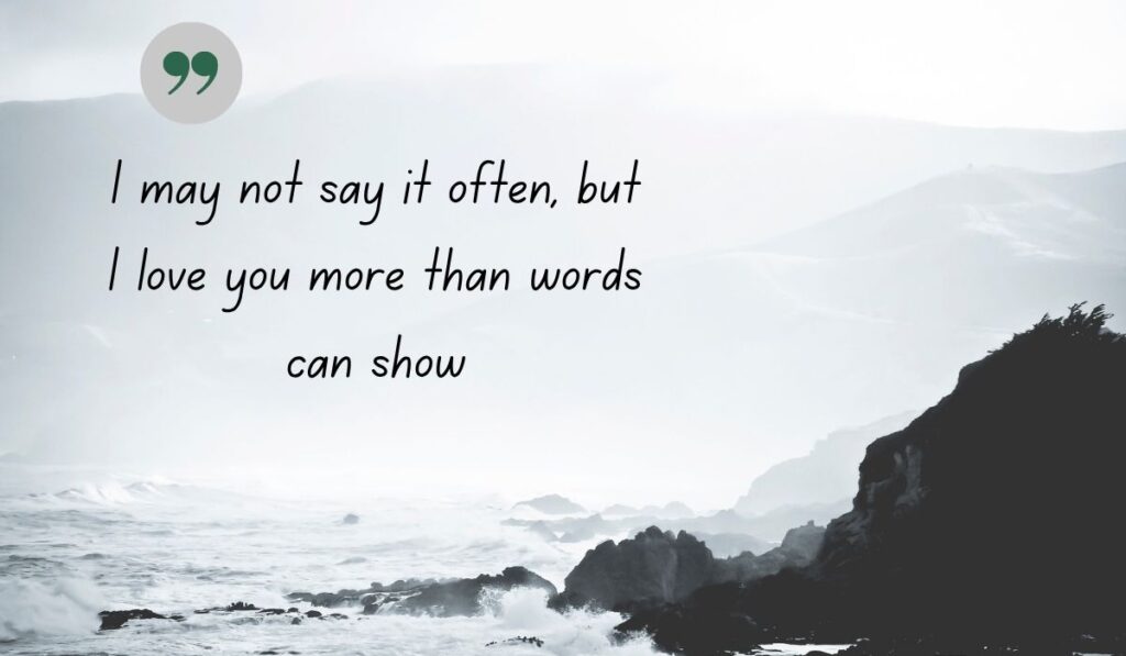 Atmospheric black and white coastal image of crashing ocean waves against rocky cliffs, centered with a thin, delicate gray circle and a dark green quotation icon framing the handwritten literary text, "I may not say it often, but I love you more than words can show".