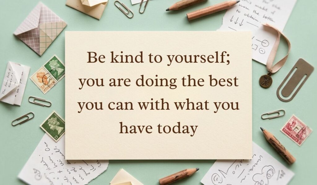 Sage green vintage desk layout with scattered paperclips, postage stamps, envelopes, and pencils featuring be kind to yourself quotes reading, "Be kind to yourself; you are doing the best you can with what you have today"