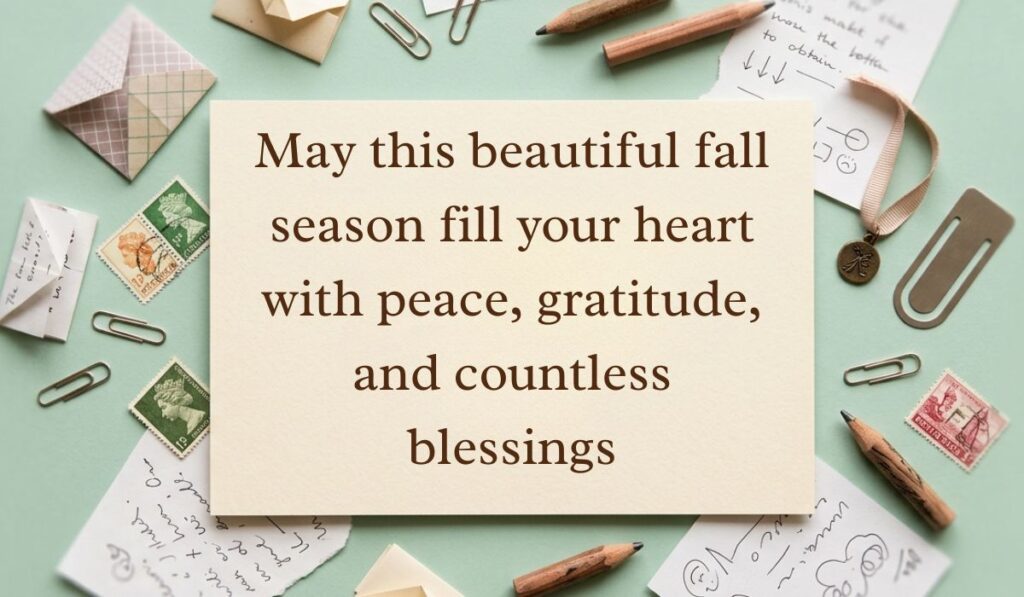 Sage green vintage desk layout with scattered paperclips, postage stamps, envelopes, and pencils displaying fall blessings quotes reading, "May this beautiful fall season fill your heart with peace, gratitude, and countless blessings"