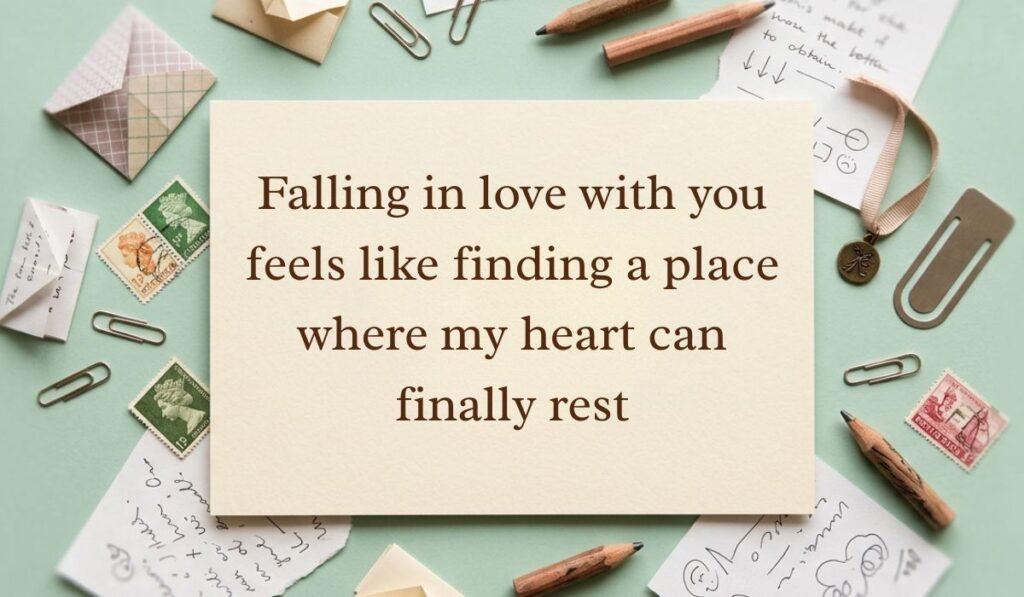 Sage green vintage desk layout with scattered paperclips, postage stamps, envelopes, and pencils featuring falling in love quotes reading, "Falling in love with you feels like finding a place where my heart can finally rest"